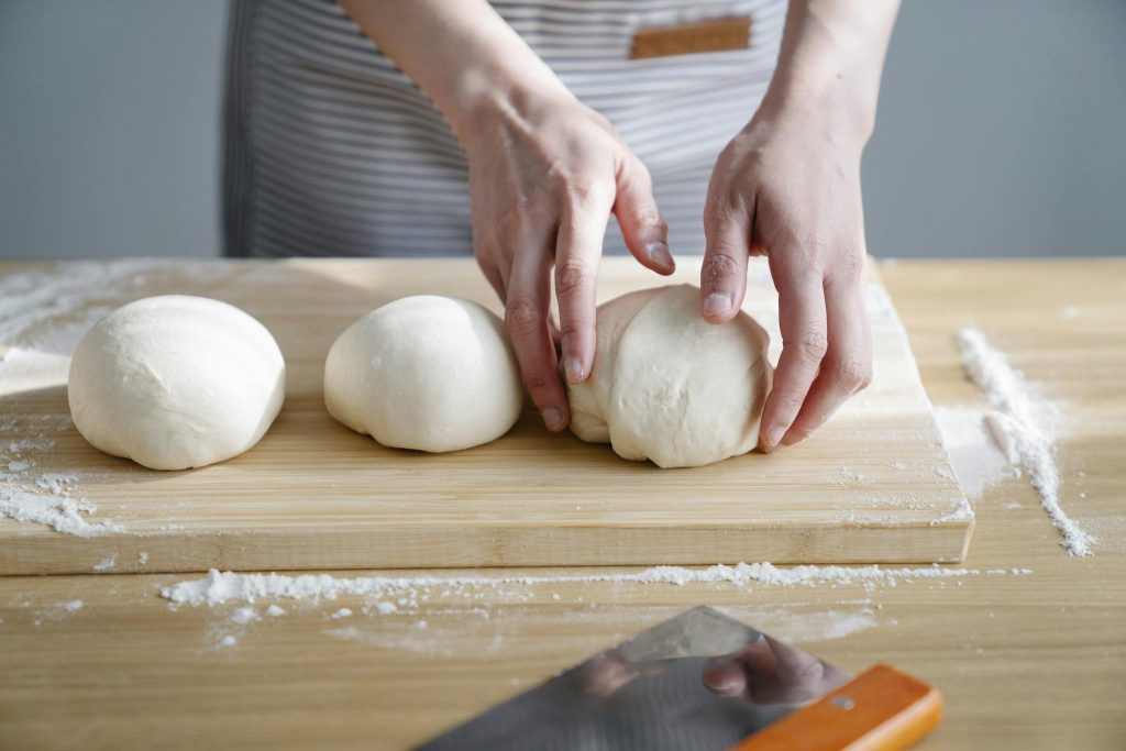 Close-up of hands working dough on a wooden board, perfect for baking themes.